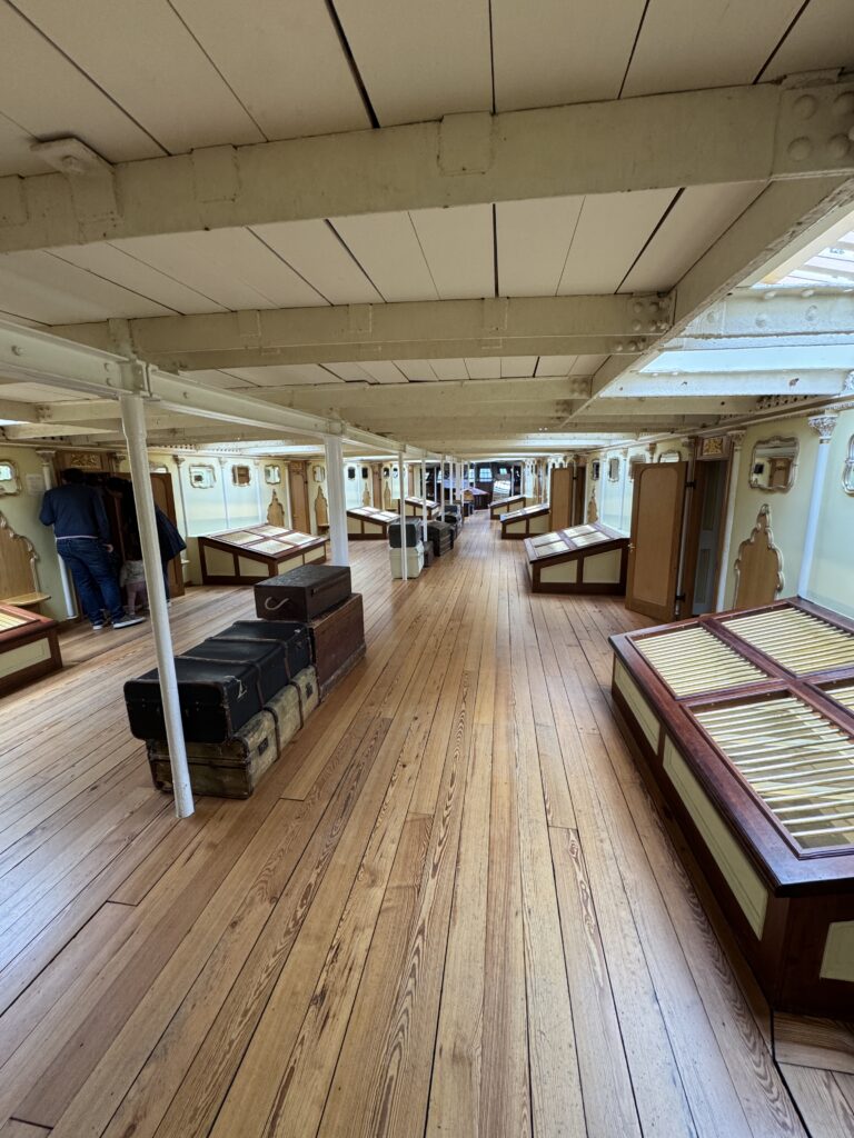 Interior corridor of the SS Great Britain with wooden floors and travel trunks
